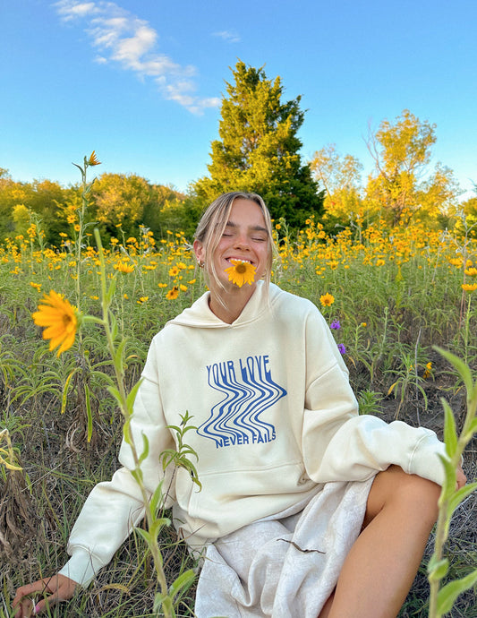 Elevated Faith Love Never Fails Cream Unisex Hoodie - AVBL MRKT (1)